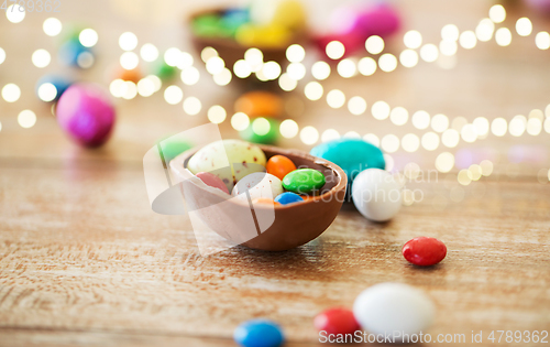 Image of chocolate easter egg and candy drops on table