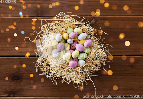 Image of easter eggs in straw nest on wooden table