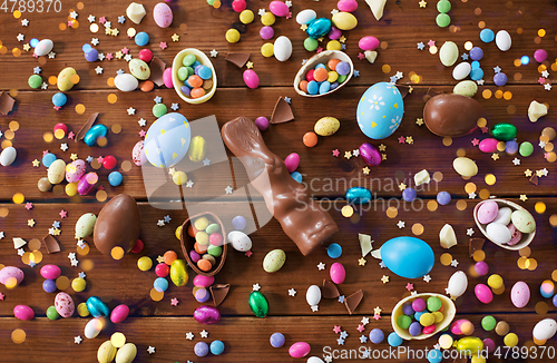 Image of chocolate eggs, easter bunny and candies on wood