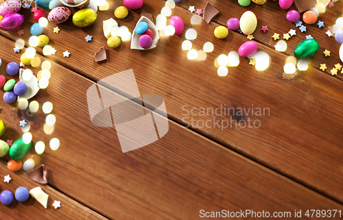 Image of chocolate eggs and candy drops on wooden table