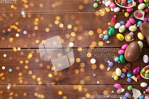 Image of chocolate eggs and candy drops on wooden table