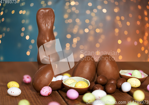 Image of chocolate eggs, easter bunny and candies on wood