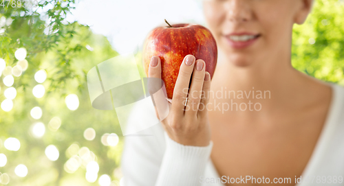 Image of close up of woman holding ripe red apple