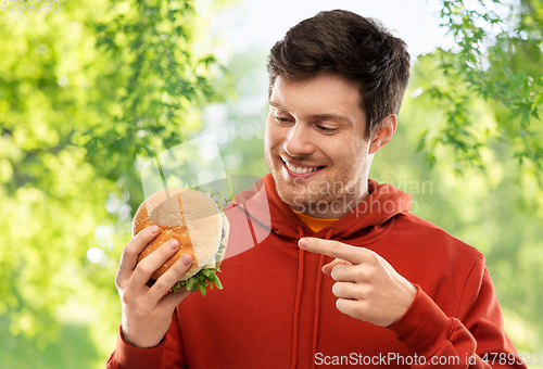 Image of happy young man showing hamburger