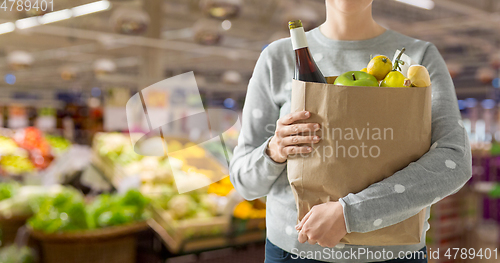 Image of close up of woman with paper bag full of food