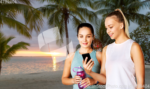 Image of women or female friends with smartphone and flask