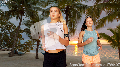 Image of young women with earphones and smartphones running