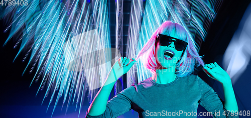 Image of woman in wig and sunglasses dancing at nightclub