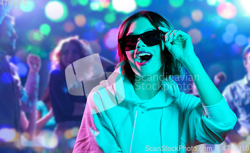 Image of woman in hoodie with sunglasses at nightclub