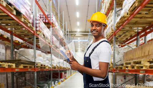 Image of happy worker or loader with clipboard at warehouse