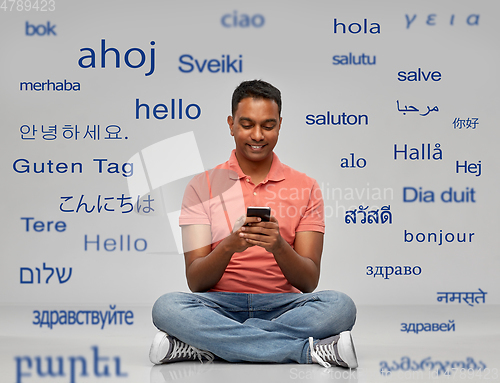 Image of happy indian man using smartphone