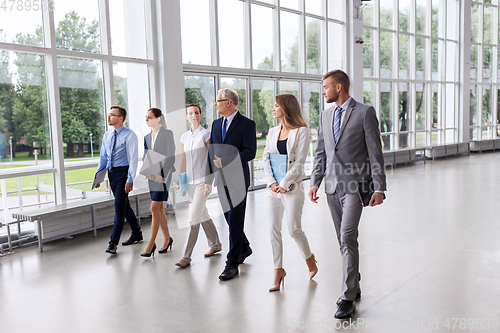 Image of business people walking along office building