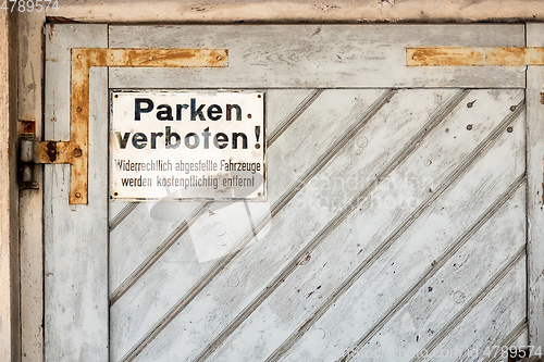 Image of private no parking sign with german text Illegally parked vehicl