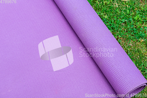 Image of Fitness mat on the green grass background