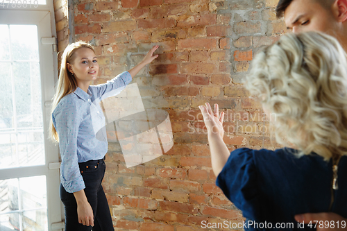 Image of Interior designer working with young couple. Lovely family and professional designer or architector.