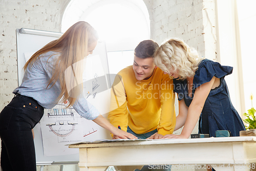 Image of Interior designer working with young couple. Lovely family and professional designer or architector.