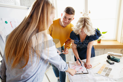 Image of Interior designer working with young couple. Lovely family and professional designer or architector.