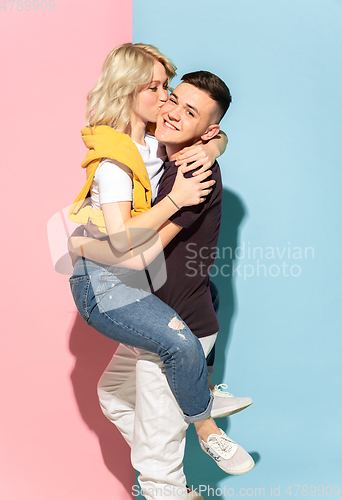 Image of Young emotional man and woman on pink and blue background