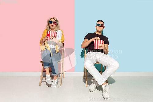 Image of Young emotional man and woman on pink and blue background