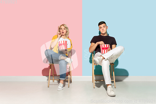 Image of Young emotional man and woman on pink and blue background