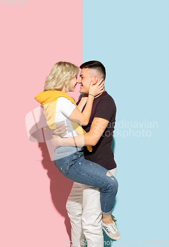 Image of Young emotional man and woman on pink and blue background