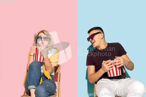 Image of Young emotional man and woman on pink and blue background