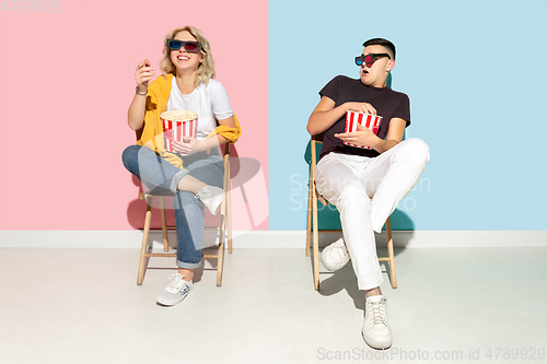 Image of Young emotional man and woman on pink and blue background