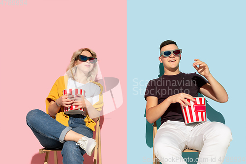 Image of Young emotional man and woman on pink and blue background