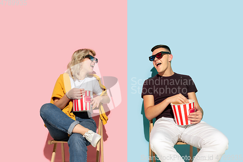 Image of Young emotional man and woman on pink and blue background