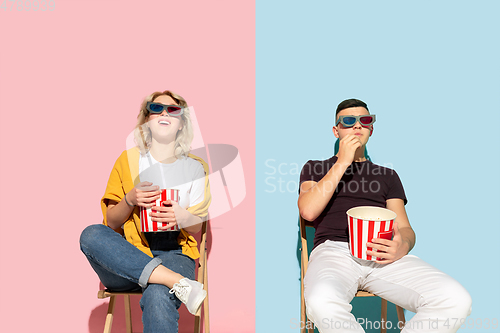 Image of Young emotional man and woman on pink and blue background