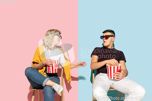 Image of Young emotional man and woman on pink and blue background
