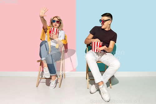 Image of Young emotional man and woman on pink and blue background