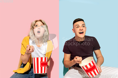 Image of Young emotional man and woman on pink and blue background