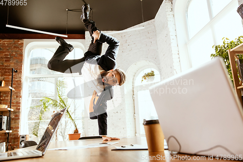 Image of Businessman having fun dancing break dance in the office at work