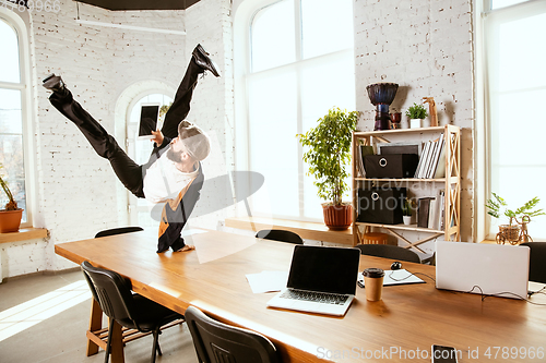 Image of Businessman having fun dancing break dance in the office at work