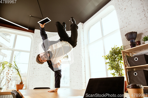 Image of Businessman having fun dancing break dance in the office at work