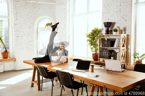 Image of Businessman having fun dancing break dance in the office at work