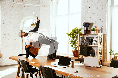 Image of Businessman having fun dancing break dance in the office at work