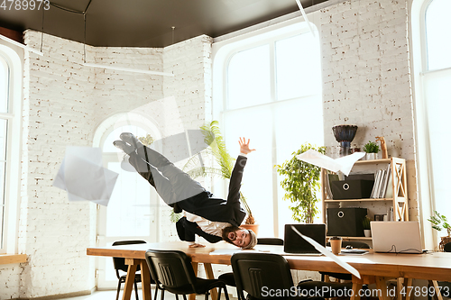 Image of Businessman having fun dancing break dance in the office at work