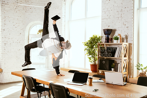 Image of Businessman having fun dancing break dance in the office at work