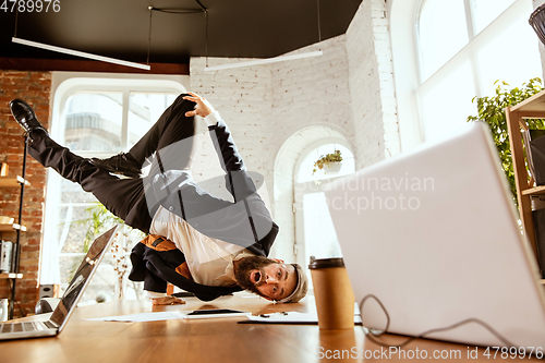 Image of Businessman having fun dancing break dance in the office at work