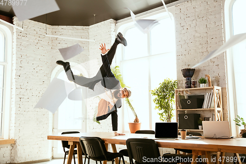 Image of Businessman having fun dancing break dance in the office at work