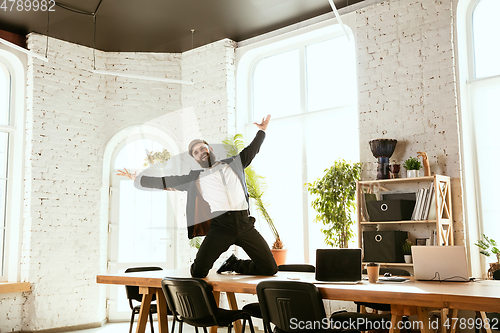 Image of Businessman having fun dancing break dance in the office at work