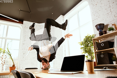 Image of Businessman having fun dancing break dance in the office at work