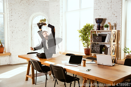 Image of Businessman having fun dancing break dance in the office at work