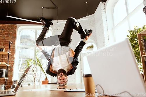 Image of Businessman having fun dancing break dance in the office at work