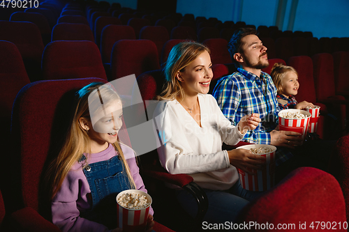 Image of Young caucasian family watching a film at a movie theater