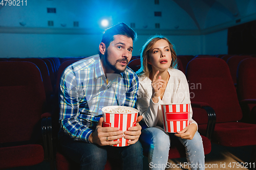 Image of Attractive young caucasian couple watching a film at a movie theater