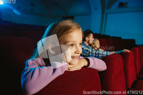 Image of Young caucasian family watching a film at a movie theater