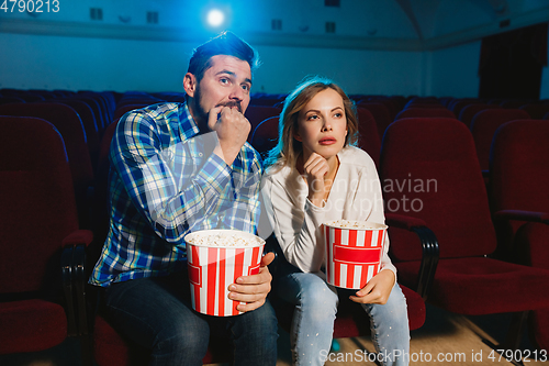 Image of Attractive young caucasian couple watching a film at a movie theater